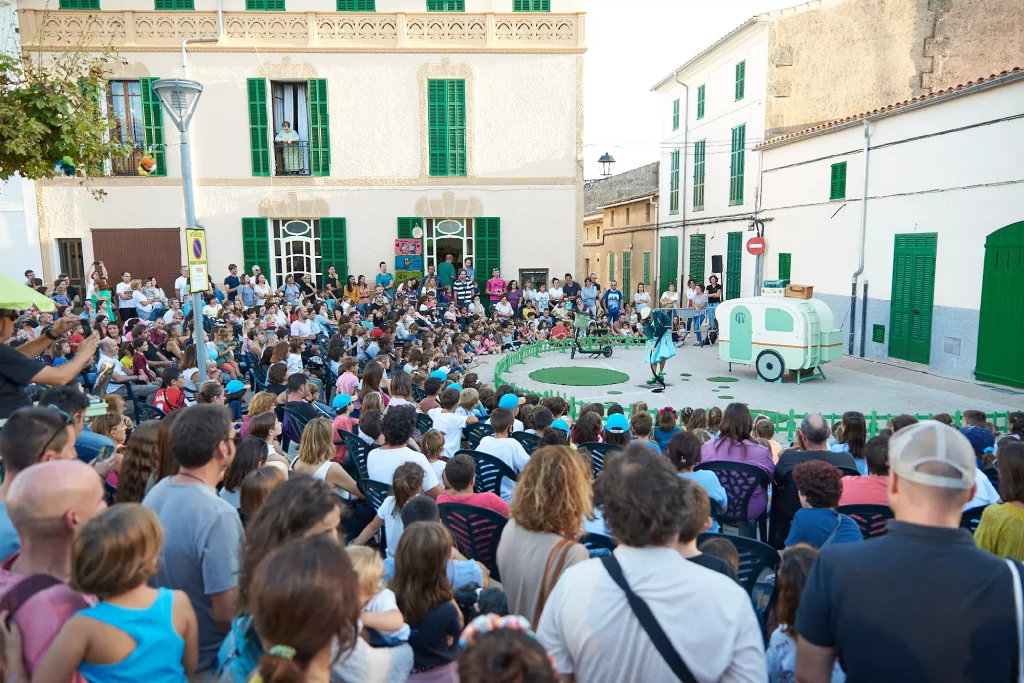 Numeroso publico de todas las edades, disfrutando de una función teatral de calle en el pueblo de Vilafranca de Bonany